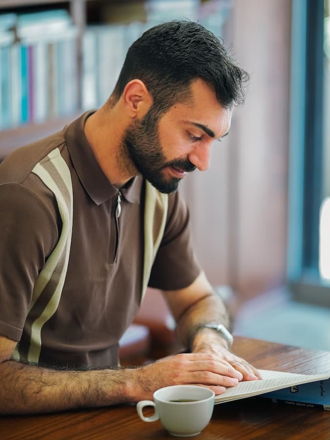 Personne faisant une pause de lecture près d’une fenêtre